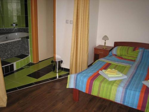 1 dormitorio con 1 cama y baño con bañera en Bazeni Baikal en Topola