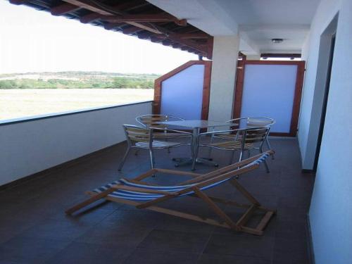 a table and chairs sitting on a balcony at Bazeni Baikal in Topola