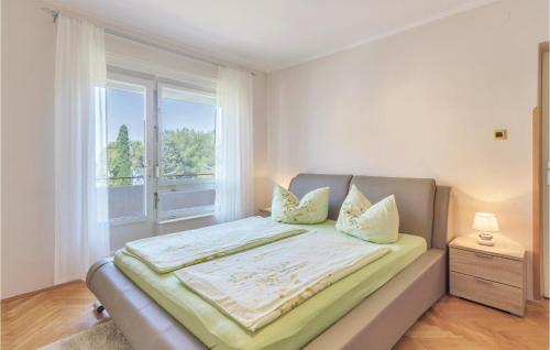 a bedroom with a large bed with a window at Beautiful Apartment In Fazana With Kitchen in Fažana