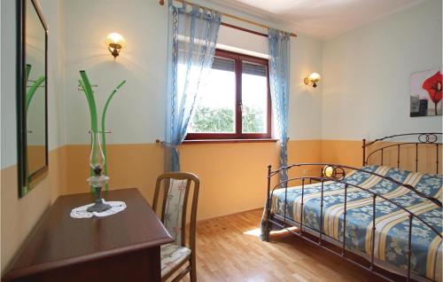 Schlafzimmer mit einem Bett, einem Tisch und einem Fenster in der Unterkunft Stunning Apartment In Medulin With 2 Bedrooms And Wifi in Medulin