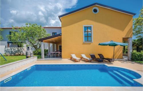 a villa with a swimming pool and a house at Holiday Home Mlaginje Iii in Žminj