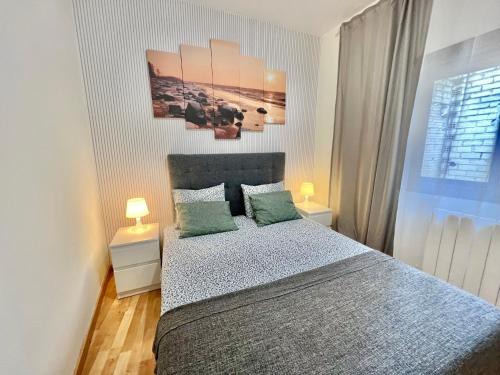 a bedroom with a bed with two green pillows at Comfortable renovated flat, WiFi! in Badalona