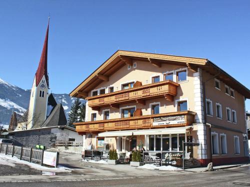 a building in front of a church with a steeple at Apartment Uderns near Hochzillertal Ski Lift in Uderns