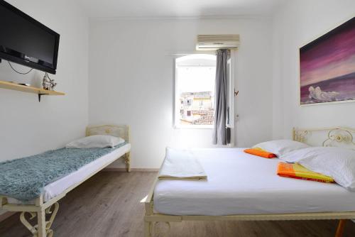 1 dormitorio con 2 camas y TV en la pared en A2 - apartment in the very heart of Split en Split