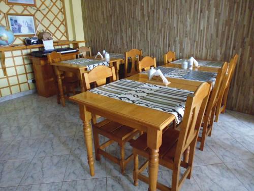 comedor con mesas y sillas de madera en Hosteria Chalp en Ushuaia