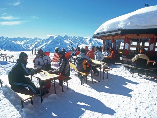 a group of people sitting at tables in the snow at Stylish Flats in Uderns near Ski Lifts in Uderns