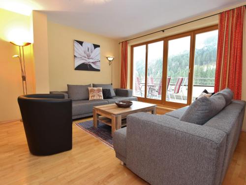 a living room with two couches and a table at Chalet apartment in Saalbach Hinterglemm in Saalbach-Hinterglemm