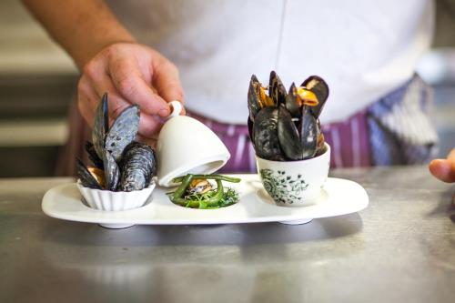 a person pouring food into cups on a plate at La Fosse at Cranborne in Cranborne