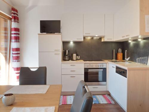 a small kitchen with white cabinets and a table and a tableablish at Lovely Apartment with Terrace in F genberg in Fügen