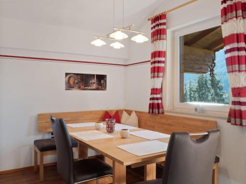 a dining room with a wooden table and chairs at Lovely Apartment with Terrace in F genberg in Fügen