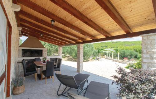 eine Terrasse mit einer hölzernen Pergola sowie einem Tisch und Stühlen in der Unterkunft Awesome Home In Smokvica With Kitchen in Smokvica