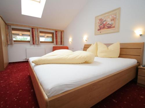 a bedroom with a large bed with white sheets at Stylish Flats in Uderns near Ski Lift in Uderns