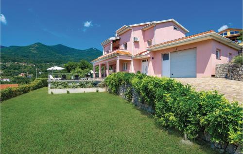 ein rosa Haus mit Rasen davor in der Unterkunft Gorgeous Home In Icici With Sauna in Ičići