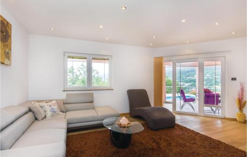 ein Wohnzimmer mit einer Couch und einem Tisch in der Unterkunft Gorgeous Home In Icici With Sauna in Ičići
