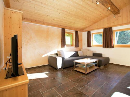 a living room with a couch and a tv at Chalet in Hopfgarten in Brixental with hot tub in Hopfgarten im Brixental