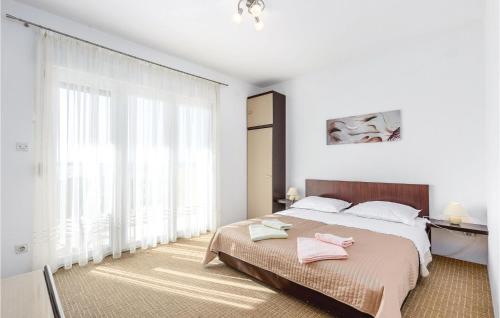 a white bedroom with a large bed with pink towels on it at 1 Bedroom Gorgeous Apartment In Selce in Selce