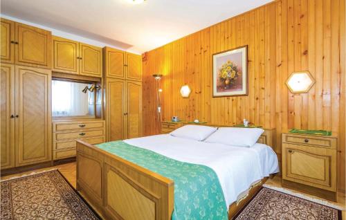 a bedroom with a large bed with wooden walls at 2 Bedroom Pet Friendly Apartment In Kolavici in Veprinac