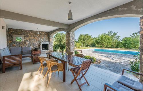 un patio con tavolo e sedie e una piscina di 4 Bedroom Nice Home In Zgaljici a Skrbčići
