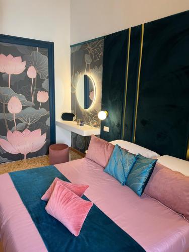 a bed with pink and blue pillows in a room at La Lepre felice-bovio in Naples