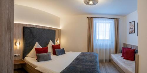 a bedroom with a large bed with red pillows at Landhaus Schiestl in Ramsau im Zillertal
