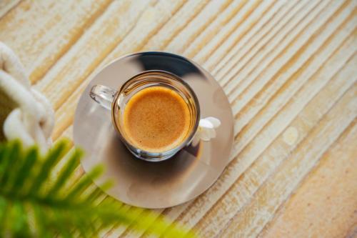 a cup of coffee on a plate on a table at Hidden Valley Residence in Au Cap