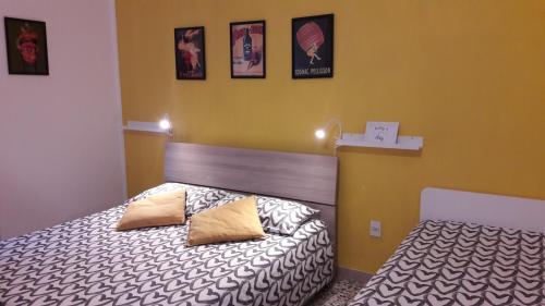 een slaapkamer met 2 bedden en foto's aan de muur bij Bolognamania Apartments-Smart in Bologna