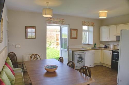 eine Küche und ein Esszimmer mit einem Tisch und einem Esszimmer gmaxwell gmaxwell in der Unterkunft Powillimount Cottage in Kirkbean
