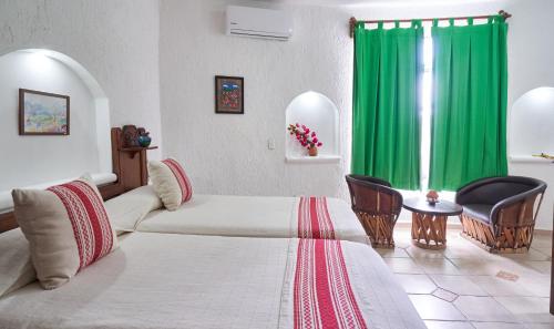 a room with two beds and a green curtain at Maison Tulum in Tulum