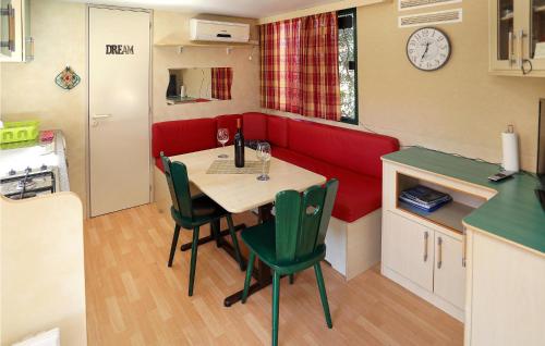 a small kitchen with a table and a red couch at Amazing stacaravan In Trogir With Kitchen in Trogir