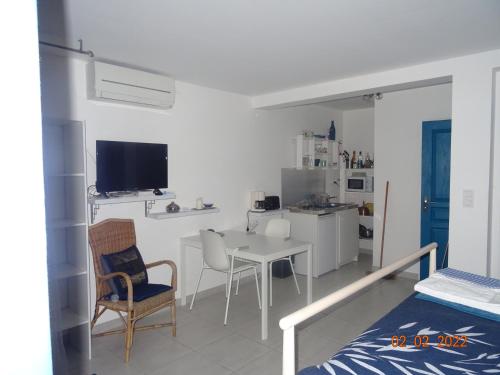 a white room with a table and chairs and a kitchen at Les Ecrins d'Aix-en-Provence in Aix-en-Provence