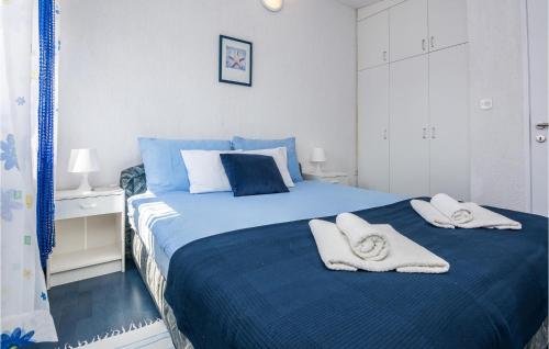 a bedroom with a blue bed with towels on it at Beautiful Apartment In Privlaka With Kitchen in Privlaka