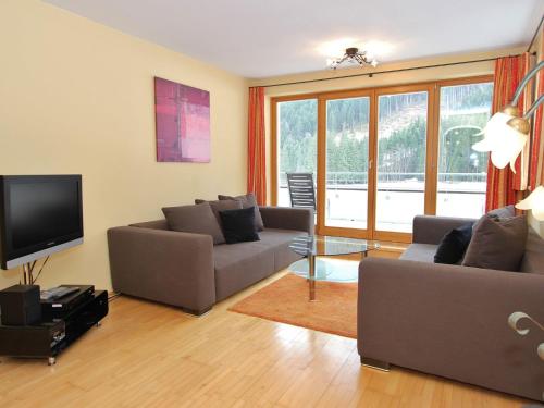 a living room with two couches and a television at Large chalet apartment in Saalbach Hinterglemm in Saalbach-Hinterglemm