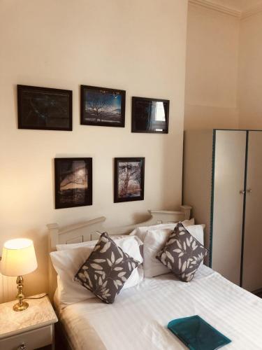 a bedroom with a bed and pictures on the wall at The Purple Tree Guest House in Torquay