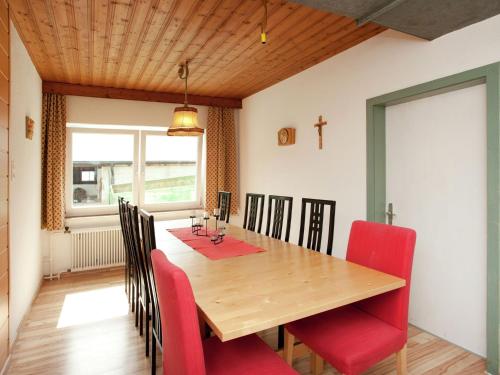 Spacious Holiday Home in Wenns near Ski Area في فينس: غرفة طعام مع طاولة خشبية وكراسي حمراء