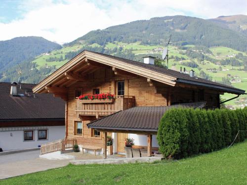 ラムサウ・イム・ツィラータールにあるBeautiful detached chalet in Mayrhofen Ramsau Tyrol with saunaの木造の家(花の咲くバルコニー付)