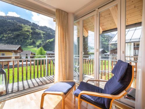 ラウリスにあるApartment in Rauris Salzburgerland near ski areaの椅子付きのポーチ、大きな窓