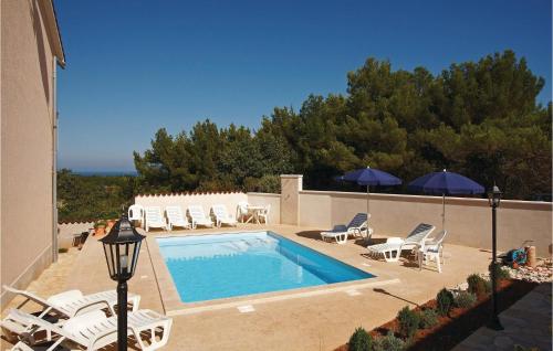 uma piscina com espreguiçadeiras e guarda-sóis em 5 Bedroom Stunning Home In Liznjan em Ližnjan
