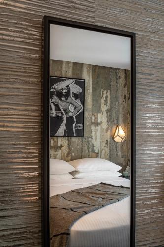 a mirror on a wall next to a bed at The FIDI Hotel in New York