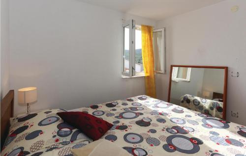 a bedroom with a bed with a comforter and a mirror at Beautiful Apartment In Slatine With 1 Bedrooms And Wifi in Slatine