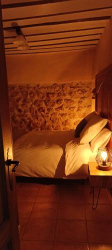 a bed with white sheets and pillows in a room at Las cuevas del agua in Chinchón
