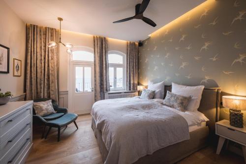 a bedroom with a large bed and a chair at Goldmädchen 93 - Beletage in Timmendorfer Strand