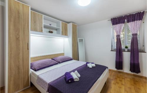 a bedroom with a large bed with purple pillows at Gorgeous Apartment In Pavicini With Kitchen in Pavicini