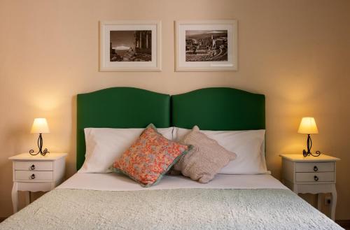 a bed with a green headboard and two nightstandumentsuments at Valentina in Taormina