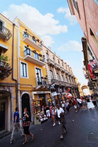 a group of people walking down a street with buildings at Valentina in Taormina