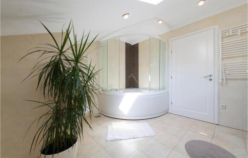 baño grande con bañera y palmera en Nice Home In Mlini-brasina With Kitchen, en Mlini