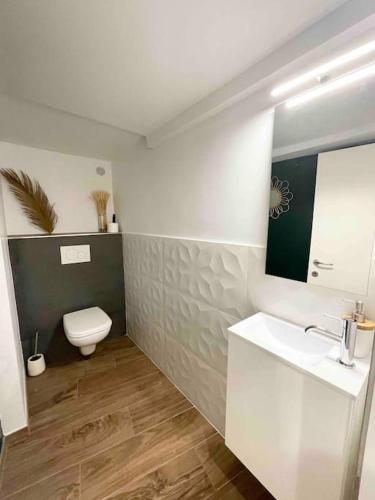 a white bathroom with a toilet and a sink at Les Logettes 2 in Menton