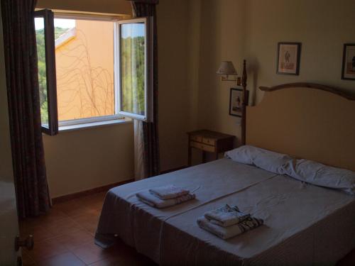 een slaapkamer met een bed met twee handdoeken erop bij Petit Paradis in Son Bou