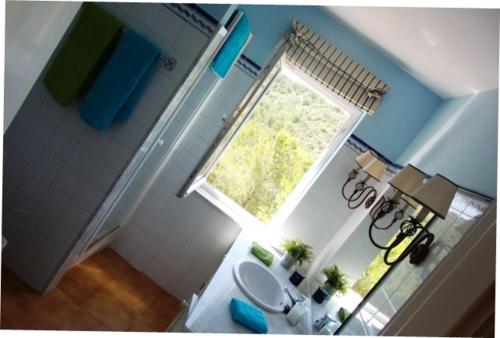 uma vista superior de uma casa de banho com um lavatório e uma janela em Petit Paradis em Son Bou
