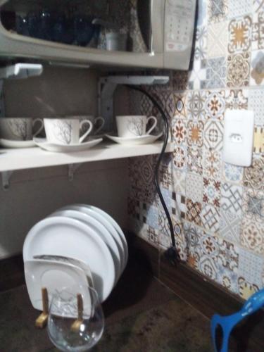 a toilet in a kitchen with a plate and a microwave at Flat Apart Hotel Ondina Barra em Salvador in Salvador
