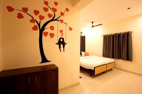 a bedroom with a tree with hearts on the wall at Thiru Pavilion Retreat in Mahabalipuram